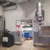 Depureco CVS centralized vacuum system with stainless steel collection unit mounted above a production discharge point.