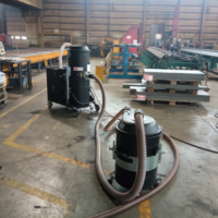 Depureco TX industrial vacuum connected by hose to a mobile pre-separator in a metalworking facility.