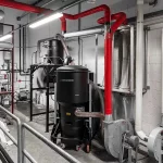 Overhead duct network from central vacuum hub serving several workstations