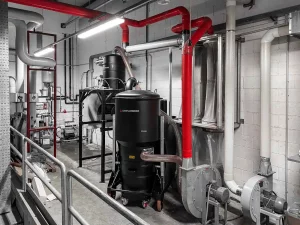 Overhead duct network from central vacuum hub serving several workstations