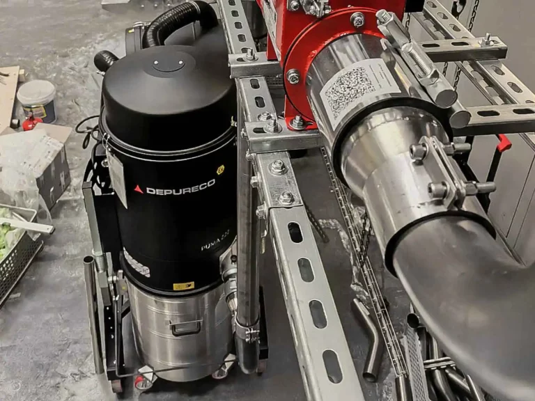 Depureco PUMA high-power industrial vacuum connected to stainless ductwork as part of a central vacuum system.
