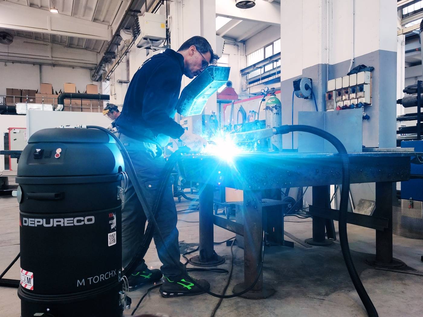 Welder using Depureco torch-mounted fume extractor on steel workpiece