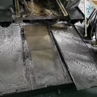 CNC sump vacuum recovering coolant, chips, and swarf from machine tank.